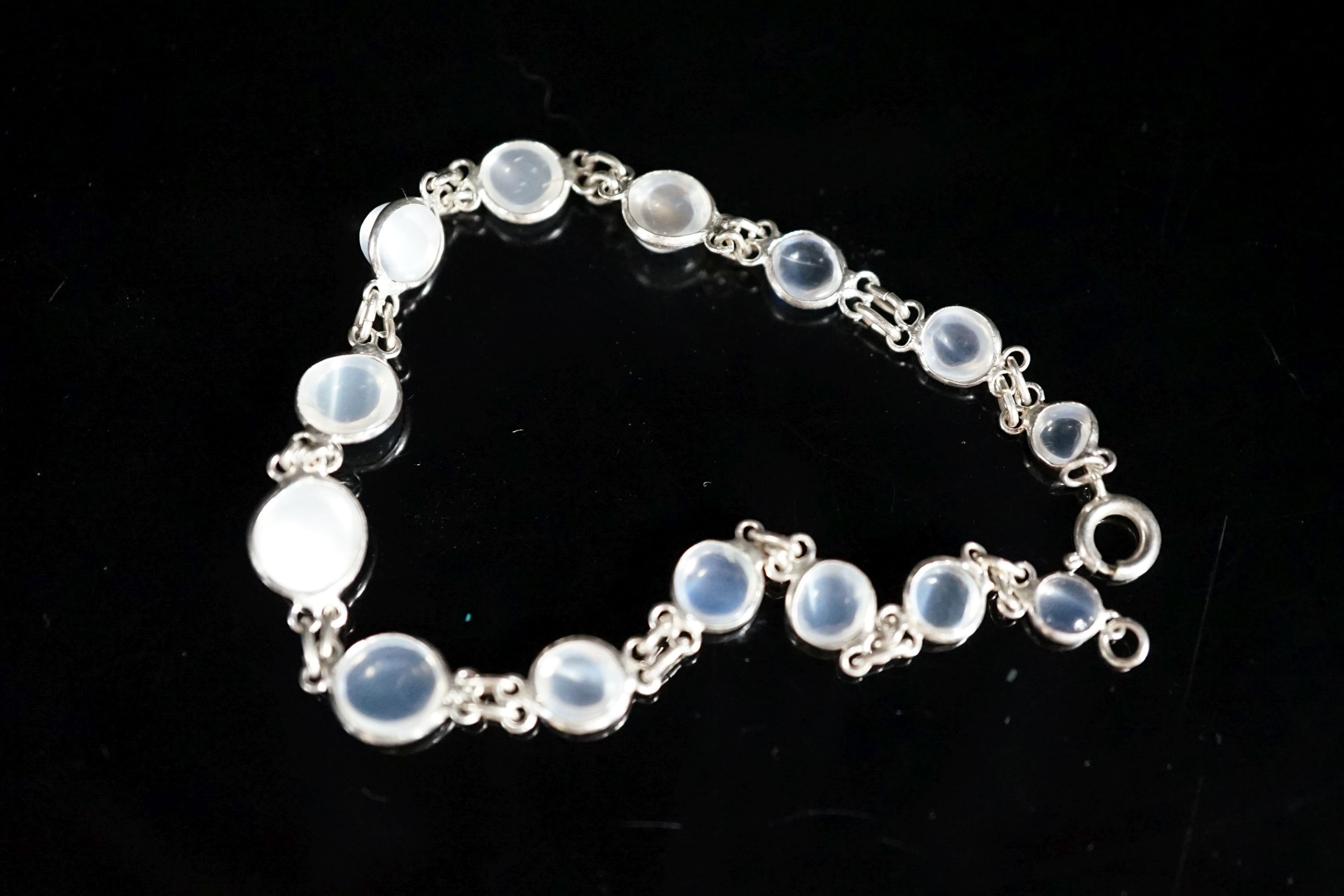 A modern (1980's) white metal and graduated moonstone set bracelet, 17cm.